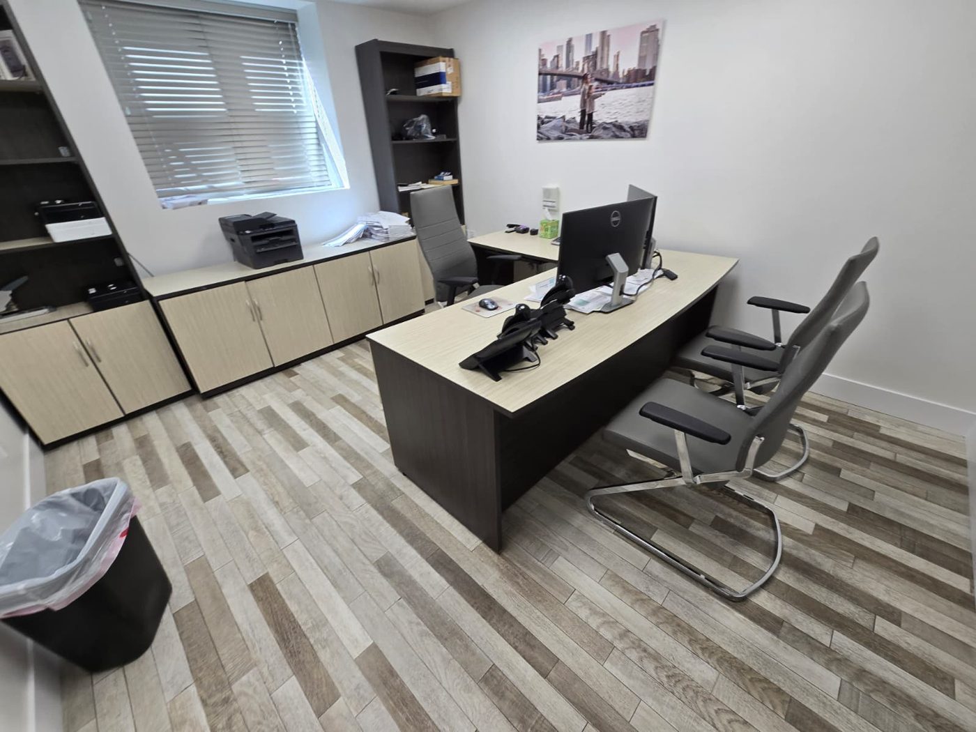Clean executive office with a wood desk, guest chairs and wood-look floor