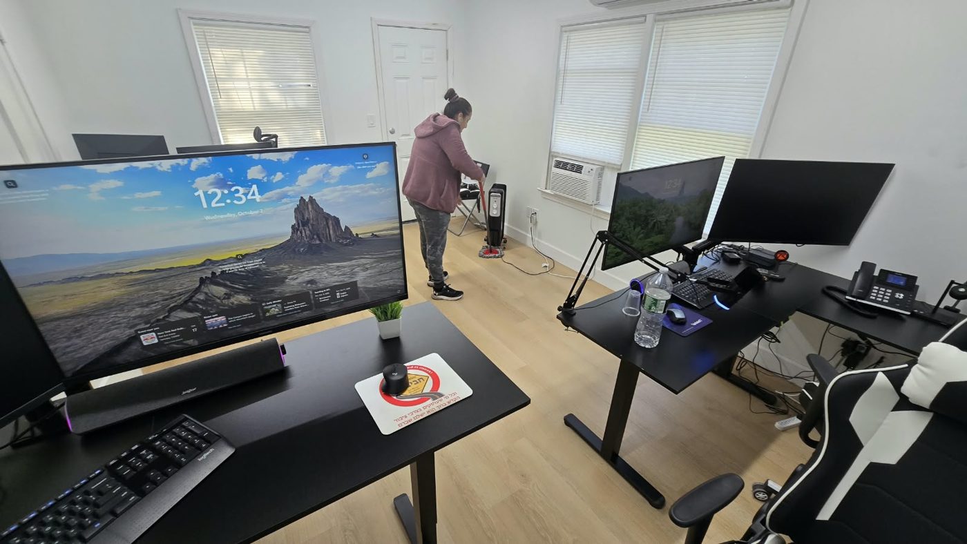 Fine Cleaning team member mopping the floor of an office with standing desks