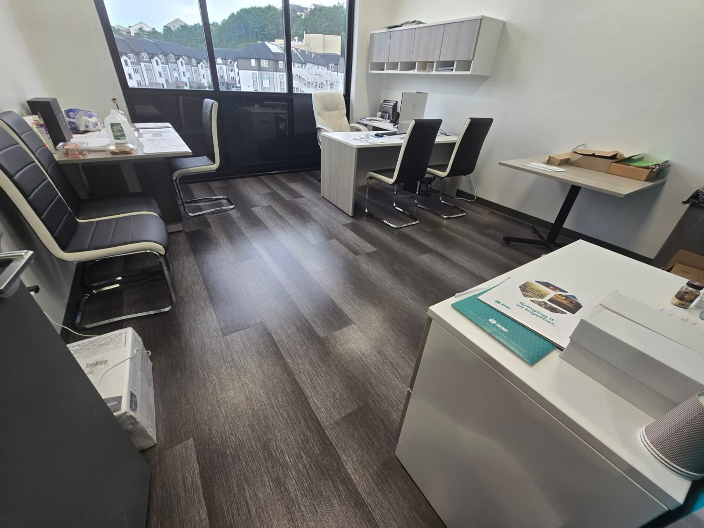 Bright office with clean desks, chairs and freshly mopped wood-look floor